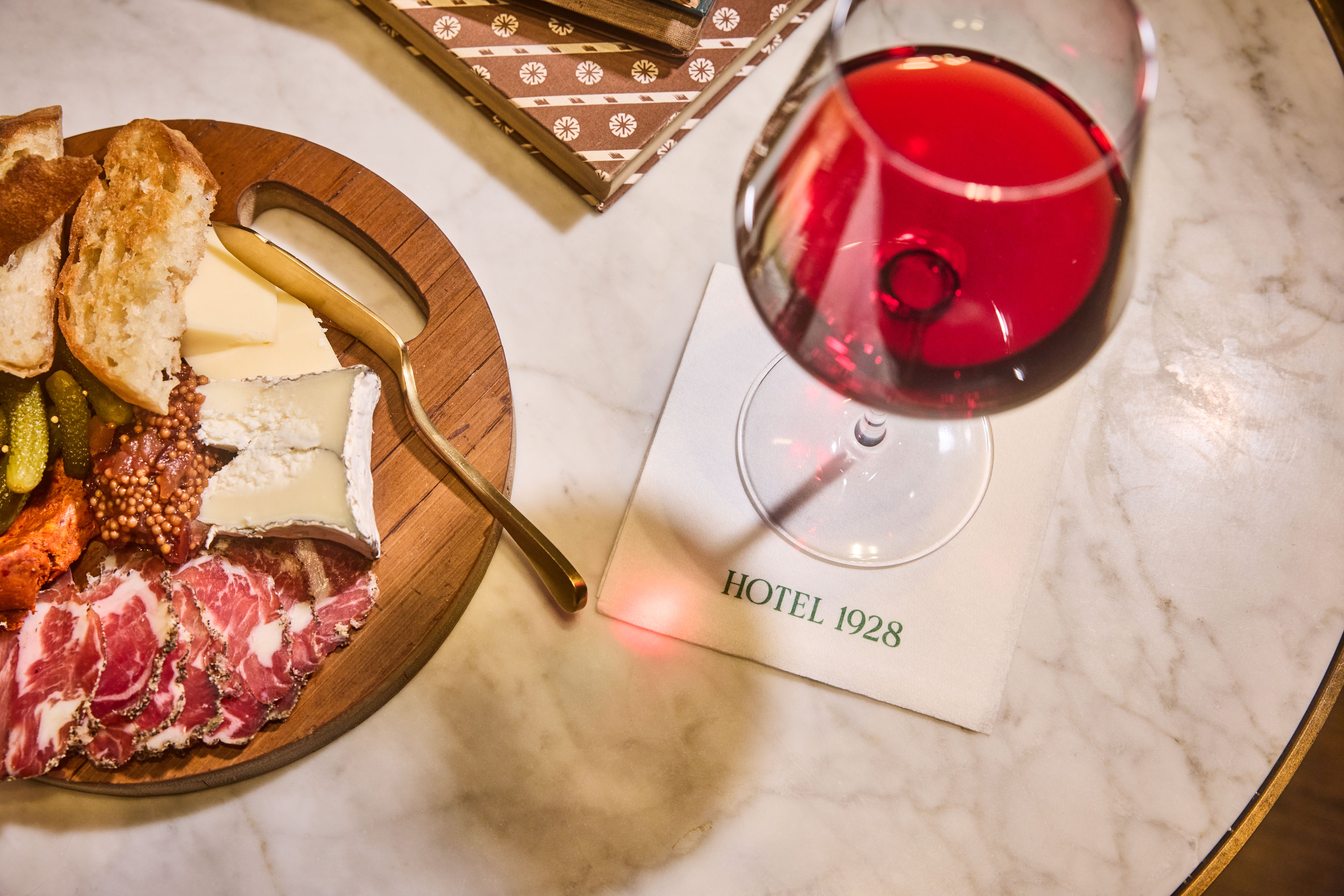 glass of wine and charcuterie on a marble table