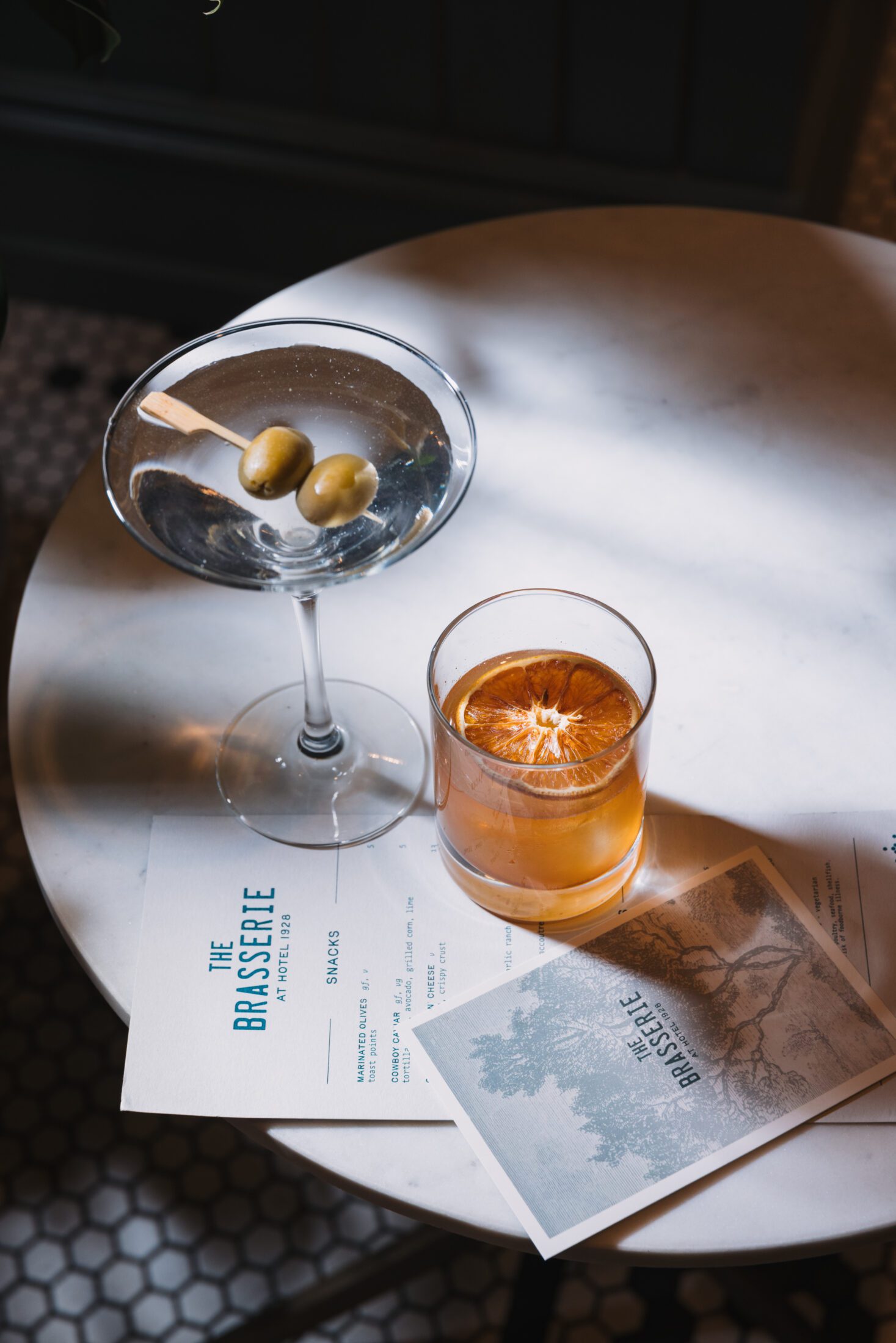 Two cocktails and a menu on a table