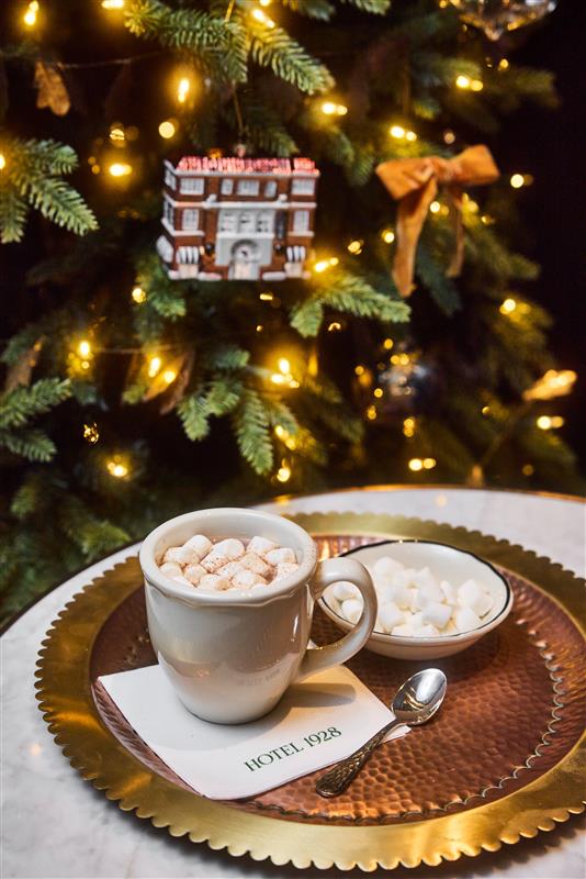 Hot chocolate with marshmallows in front of a Christmas tree