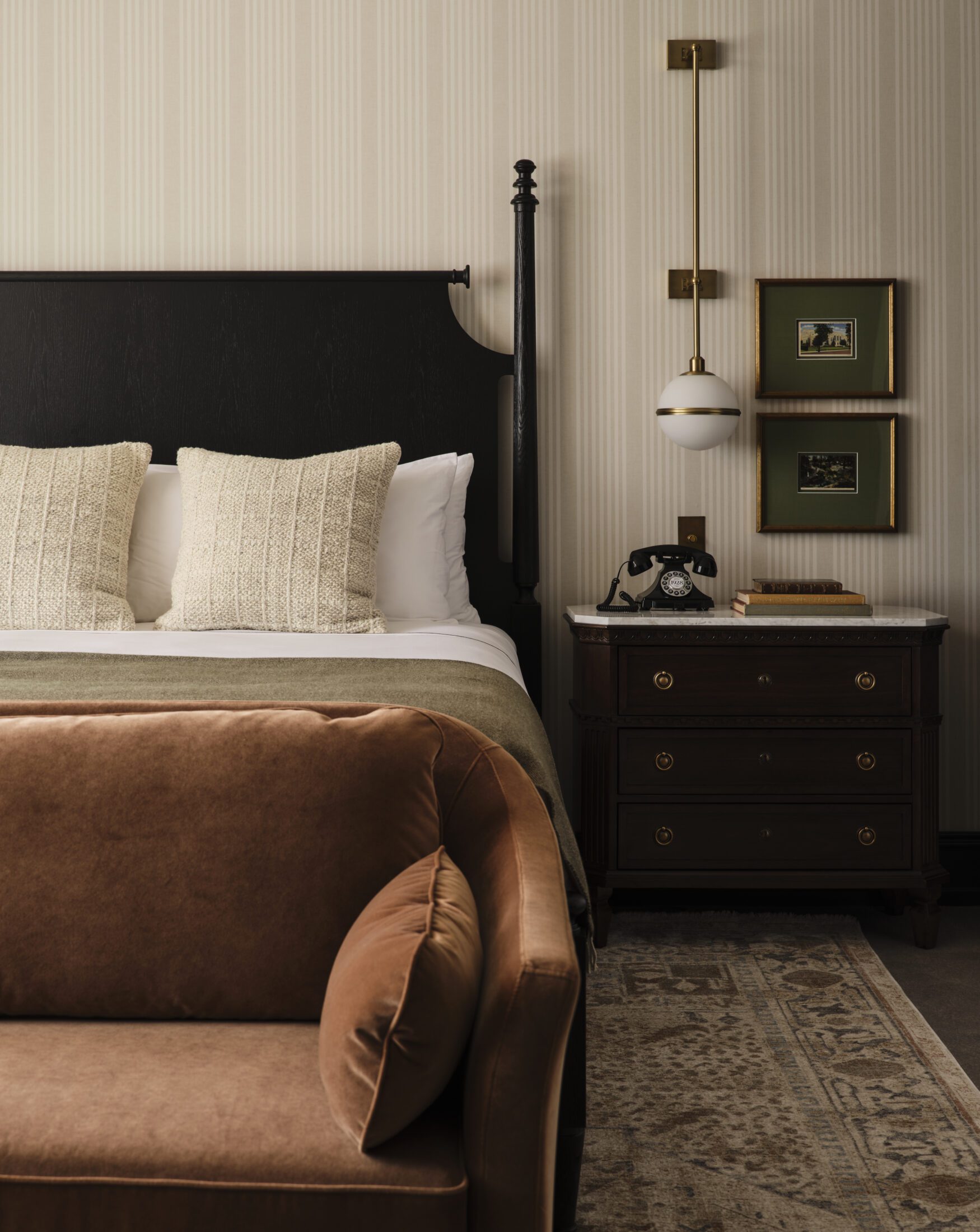 Straight on view of hotel room bed with couch and bedside table
